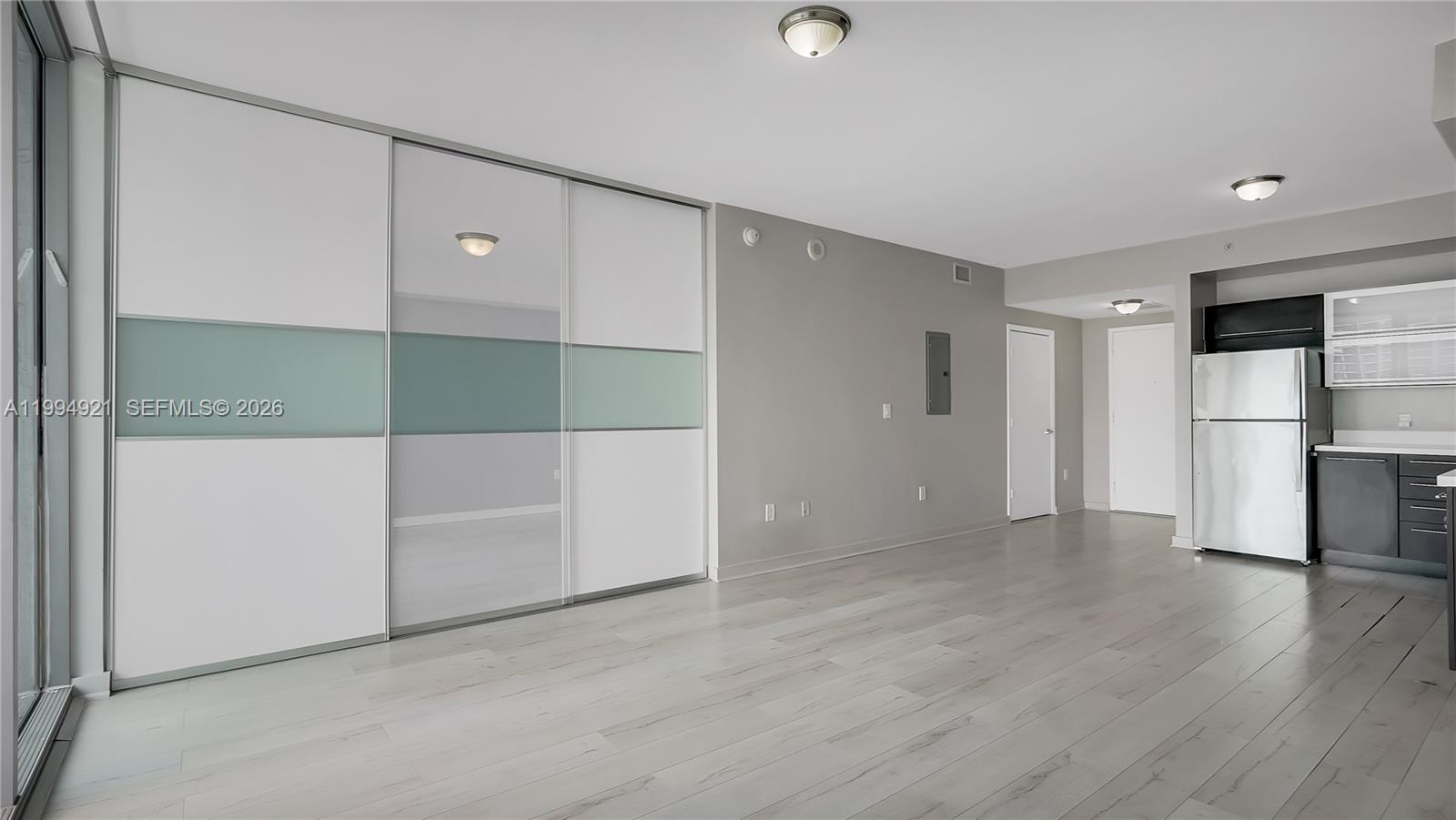 90 Southwest 3rd Street, Unit 3003 Miami, FL 33130 - Photo 10 of 47 an empty room with wooden floor and cabinet