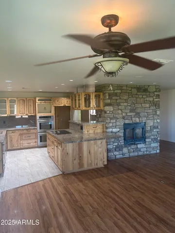 a kitchen with stainless steel appliances granite countertop a stove a sink and a wooden floors