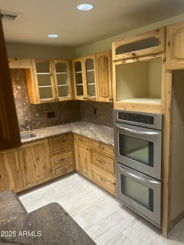 a kitchen with granite countertop a stove and a sink