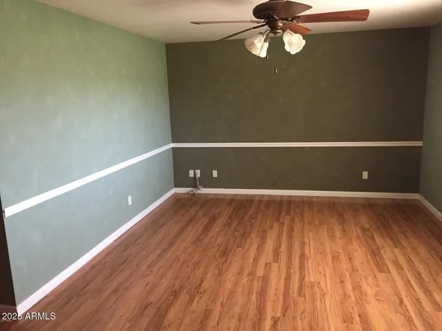 a view of room with wooden floor and fan