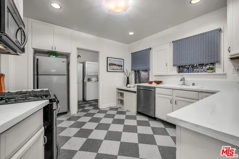 a kitchen with a sink a stove a refrigerator and cabinets