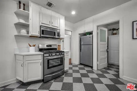 a kitchen with stainless steel appliances granite countertop a refrigerator and a stove top oven