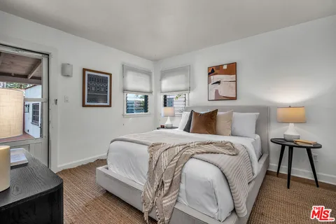 a spacious bedroom with a bed and a lamp