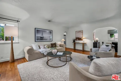 a living room with furniture potted plant and a wooden floor