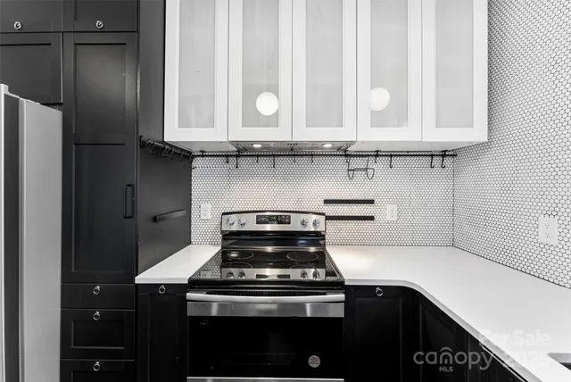 a kitchen with granite countertop white cabinets and black appliances
