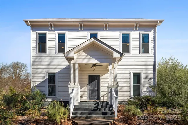 a front view of a house with plants