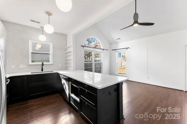 a kitchen with kitchen island granite countertop a stove and a sink