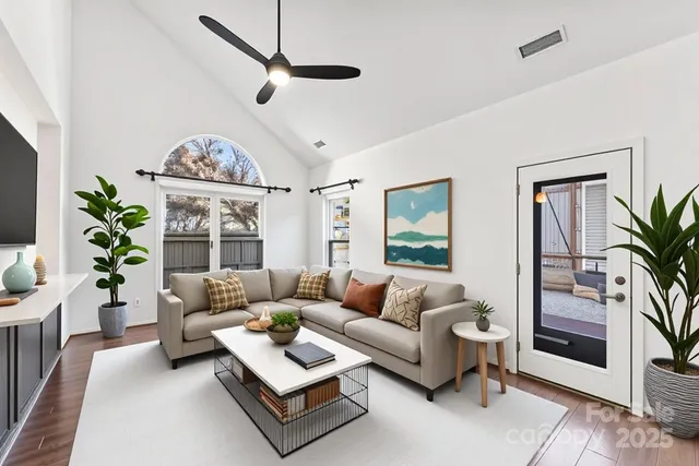 a living room with furniture a chandelier and a window