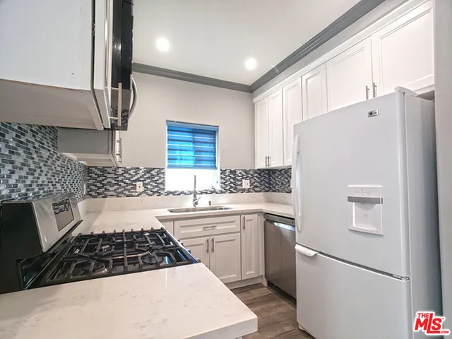 a kitchen with white cabinets and white appliances
