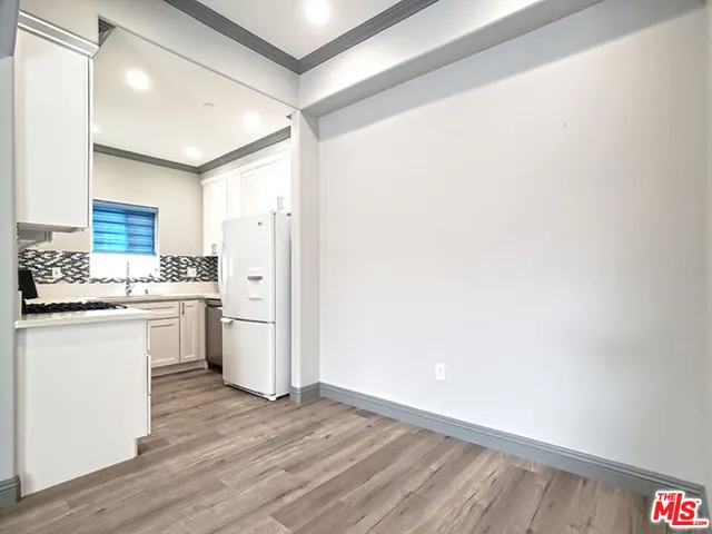a kitchen with white cabinets and white appliances