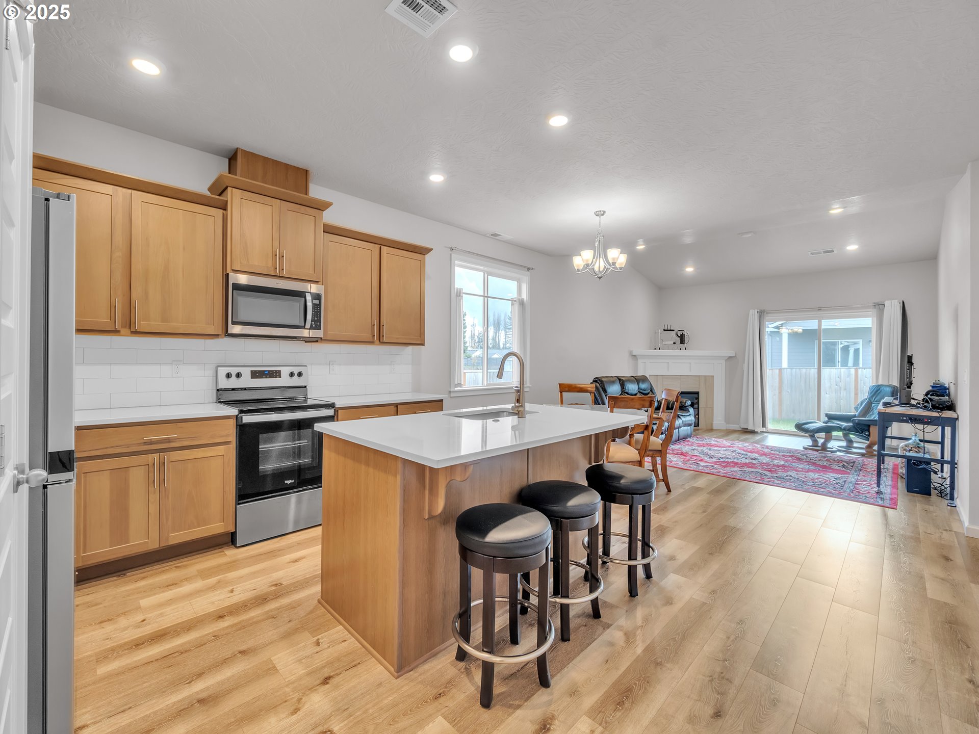 893 East Cleveland Street Carlton, OR 97111 - Photo 5 of 19 a open kitchen with stainless steel appliances granite countertop a stove top oven a sink dishwasher a dining table and chairs with wooden floor
