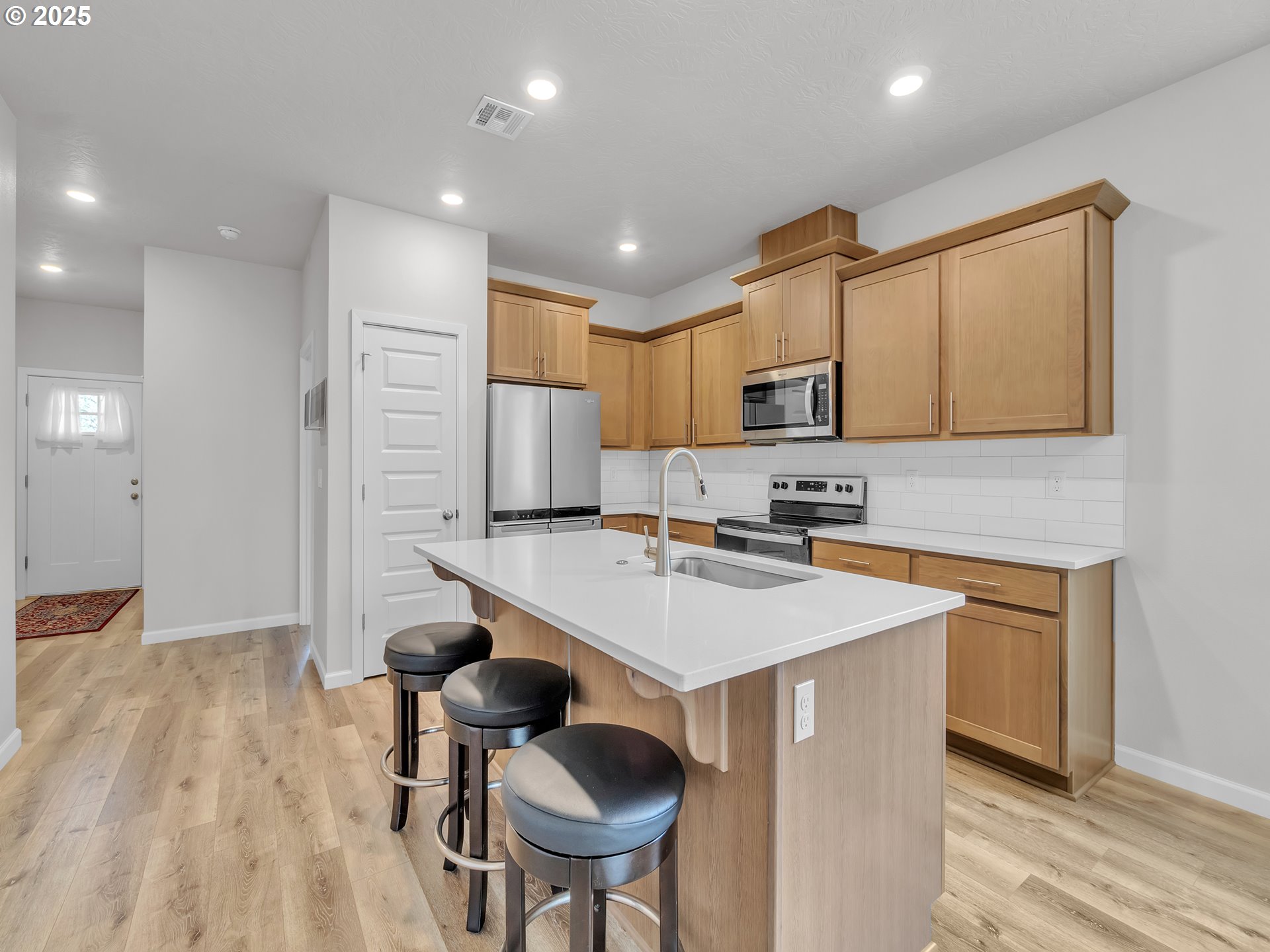 893 East Cleveland Street Carlton, OR 97111 - Photo 6 of 19 a kitchen with stainless steel appliances granite countertop a sink a stove a refrigerator cabinets and a dining table