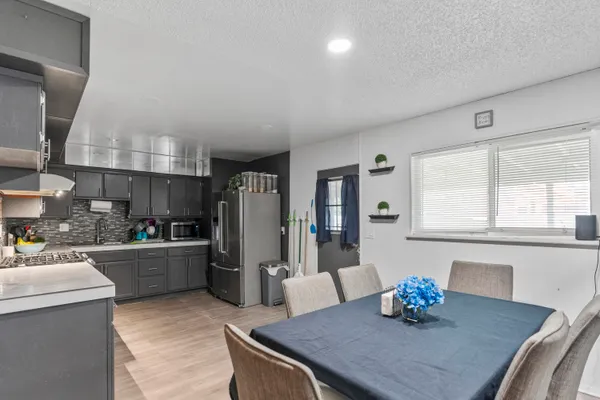 a kitchen with a table chairs and refrigerator
