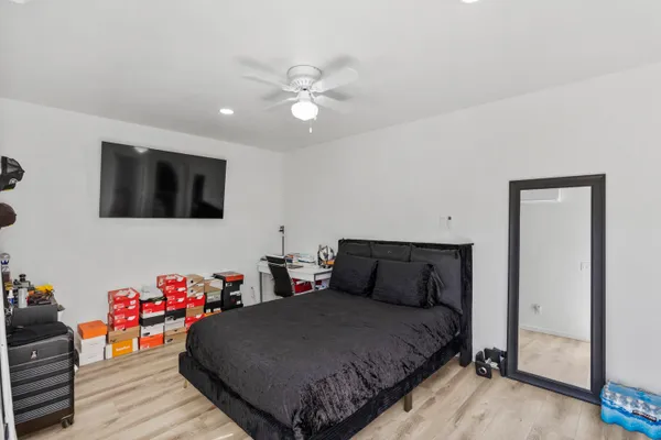 a bedroom with a bed and wooden floor