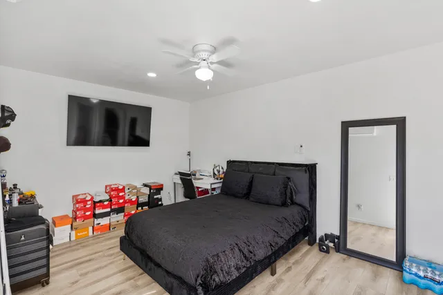 a bedroom with a bed and wooden floor