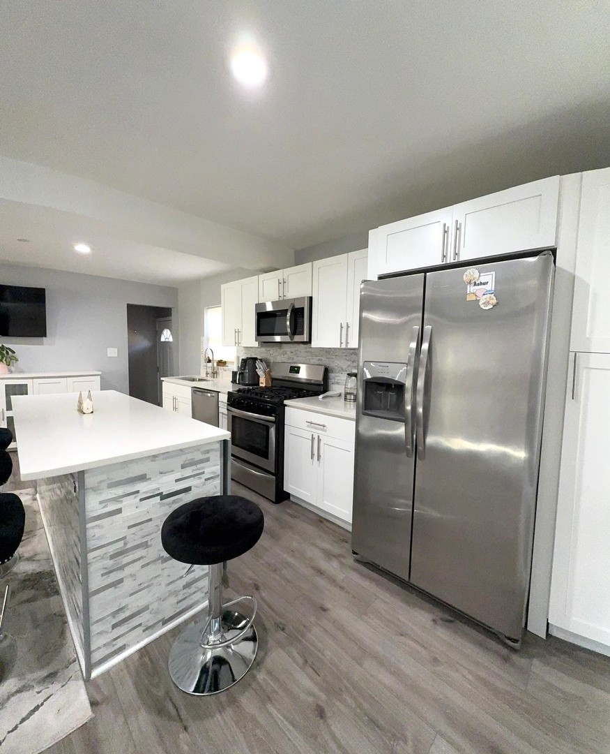 8001 North Elmore Street Niles, IL 60714 - Photo 14 of 34 a kitchen with kitchen island a counter top space appliances and cabinets