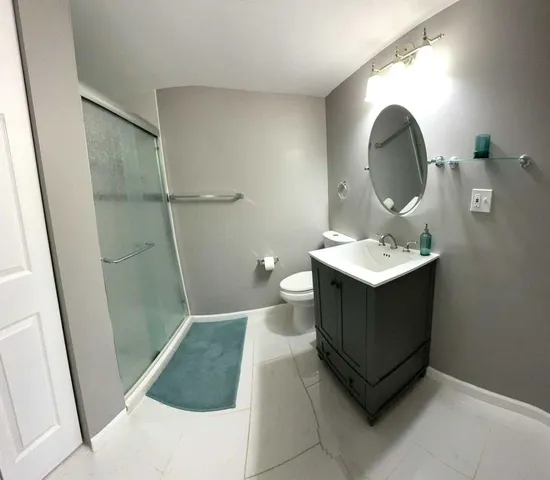 a bathroom with a sink a toilet and shower