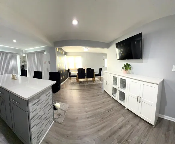 a living room with stainless steel appliances furniture and a flat screen tv