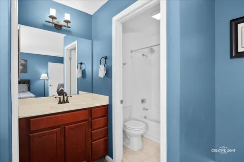 a bathroom with a sink vanity granite toilet and a mirror