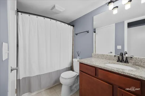 a bathroom with a granite countertop sink toilet and mirror