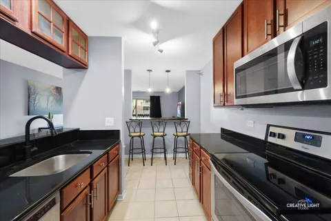 a kitchen with stainless steel appliances granite countertop a stove a sink a microwave and dining table