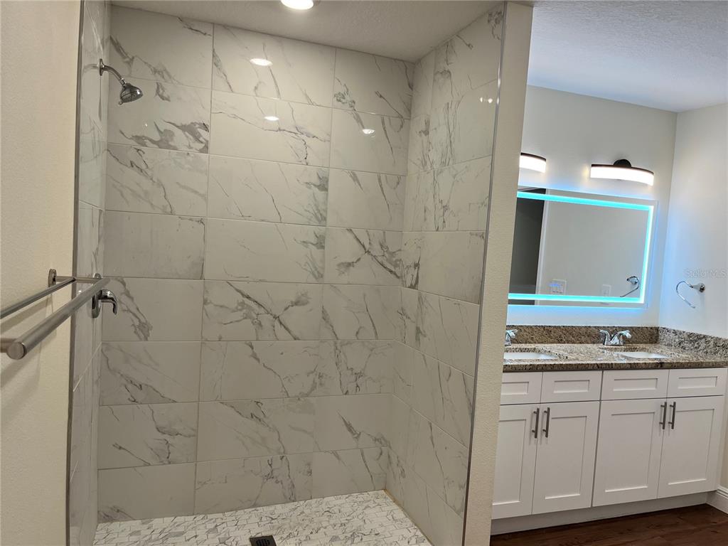 4441 Palmarito Street Sebring, FL 33872 - Photo 16 of 33 a bathroom with a granite countertop sink a mirror and shower