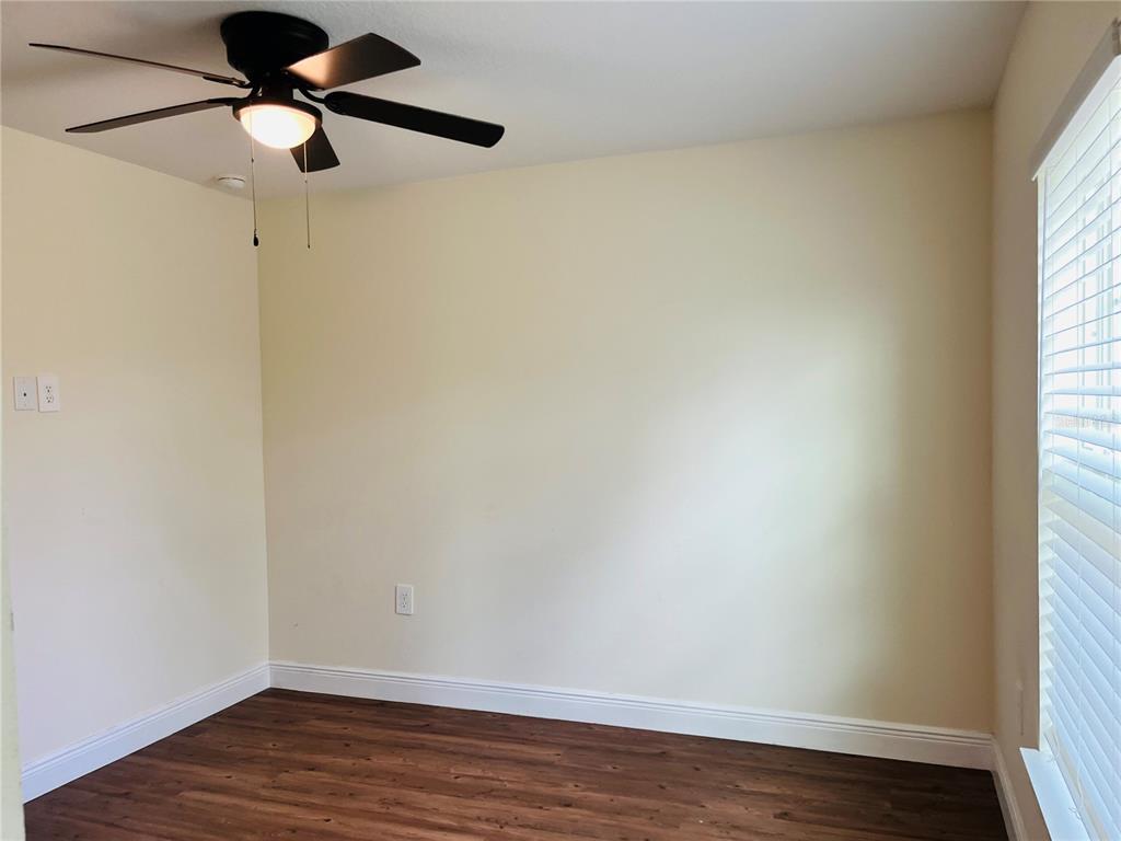 4441 Palmarito Street Sebring, FL 33872 - Photo 19 of 33 a view of an empty room with wooden floor and a window