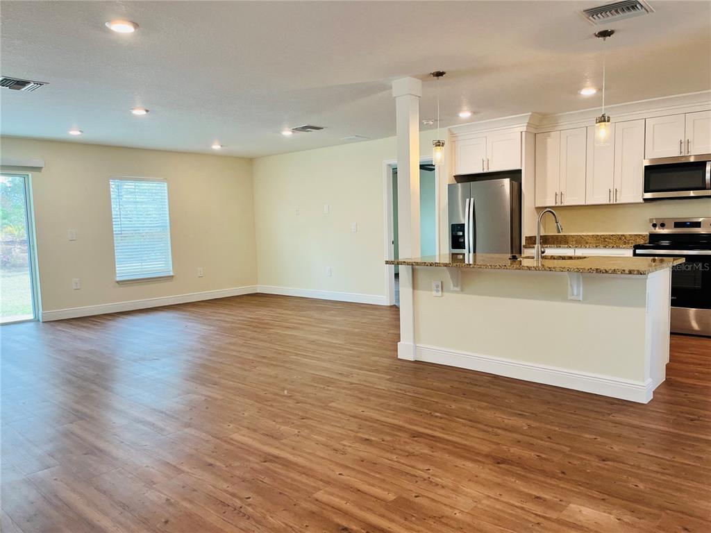 4441 Palmarito Street Sebring, FL 33872 - Photo 5 of 33 a large kitchen with stainless steel appliances a large counter top a stove and a refrigerator