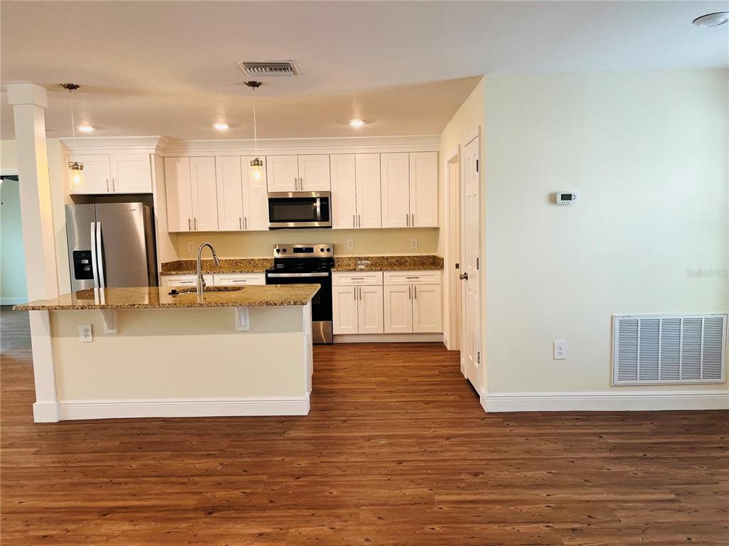 4441 Palmarito Street Sebring, FL 33872 - Photo 6 of 33 a large kitchen with stainless steel appliances granite countertop a stove a sink and a refrigerator