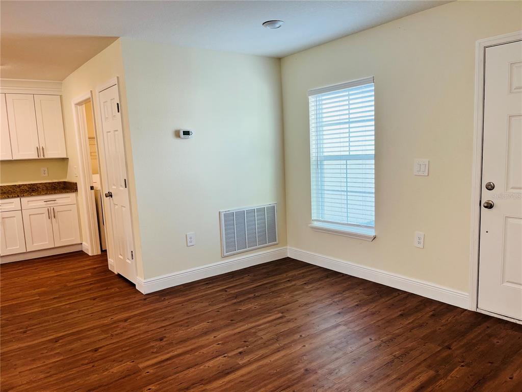 4441 Palmarito Street Sebring, FL 33872 - Photo 9 of 33 a view of an empty room with wooden floor and a window
