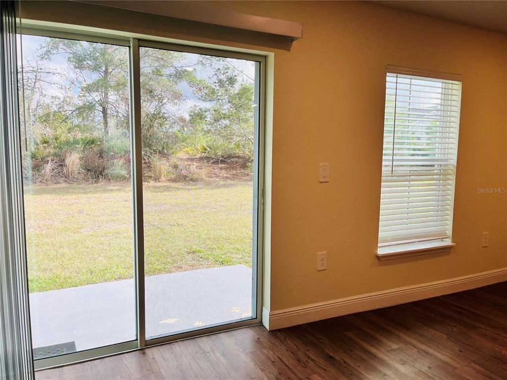 4441 Palmarito Street Sebring, FL 33872 - Photo 10 of 33 a view of an empty room with wooden floor and windows