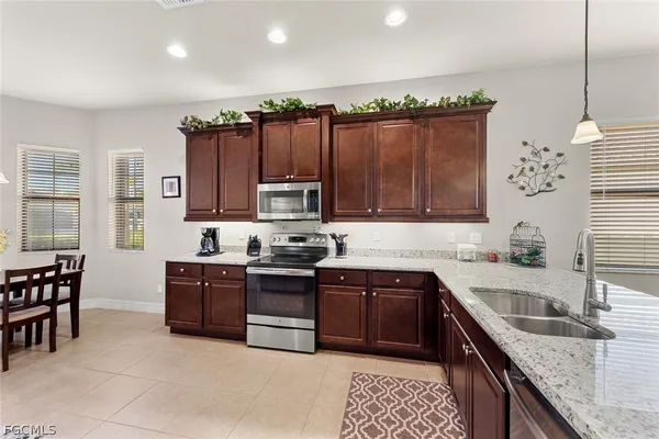 a kitchen with stainless steel appliances granite countertop a sink stove and cabinets