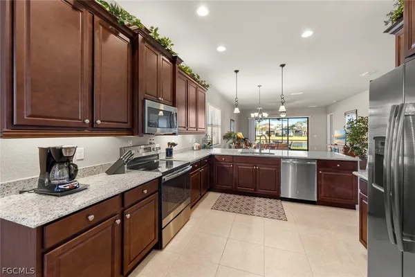 a kitchen with stainless steel appliances granite countertop a sink a stove and a refrigerator