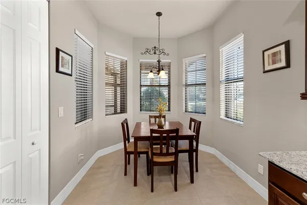 a dining room with wooden floor a chandelier a wooden table and chairs