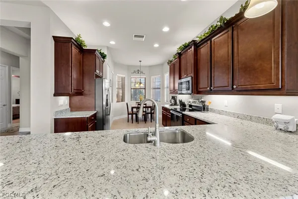 a kitchen with stainless steel appliances granite countertop a sink refrigerator and microwave