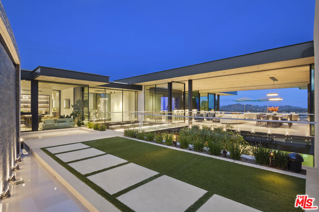 445 Walker Drive Beverly Hills, CA 90210 - Photo 2 of 30 a view of a patio with table and chairs with wooden floor and fence