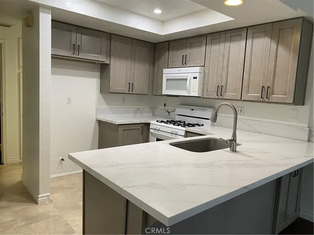 a kitchen that has a sink and a stove in it
