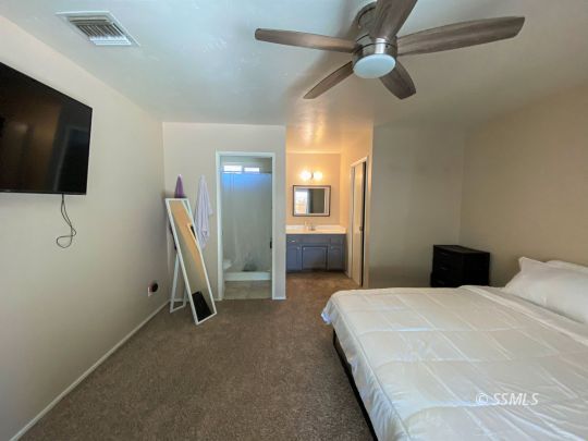 205 Kimberly Lane Ridgecrest, CA 93555 - Photo 27 of 39 a bedroom with a bed and a flat screen tv