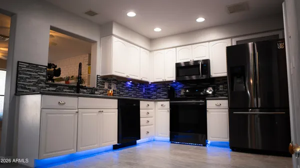 a kitchen with stainless steel appliances granite countertop a refrigerator and a stove top oven