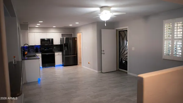 en empty room with windows and chandelier fan