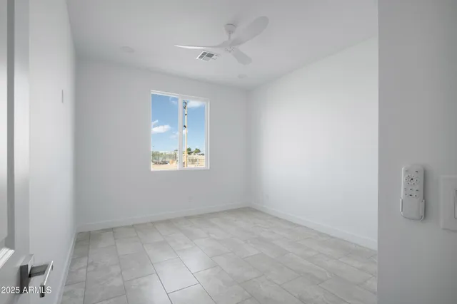 an empty room with a ceiling fan and window