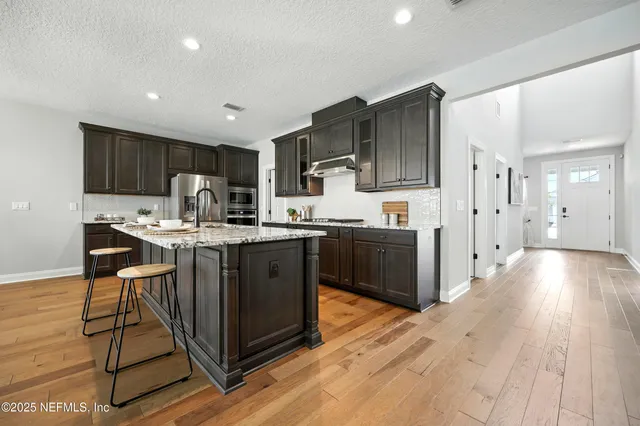a view of a hallway with wooden floor and entryway