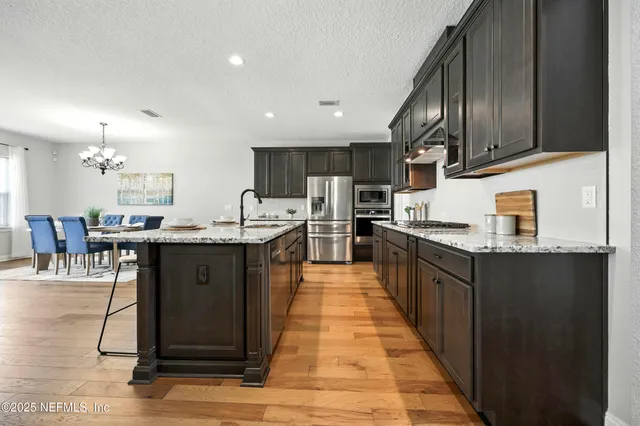 a kitchen with a sink a stove a refrigerator and cabinets