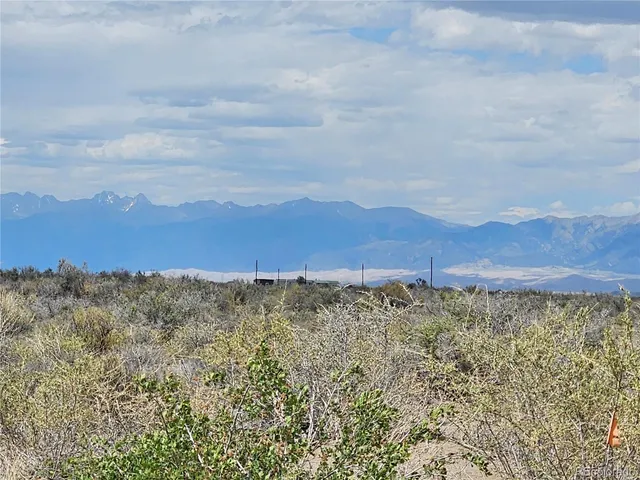 a view of a dry yard with mountains in the background