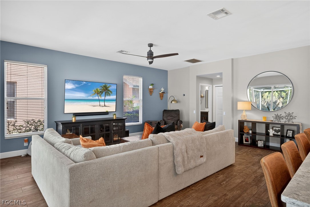 22866 Forest Ridge Drive Estero, FL 33928 - Photo 12 of 38 a living room with furniture a chandelier and a flat screen tv