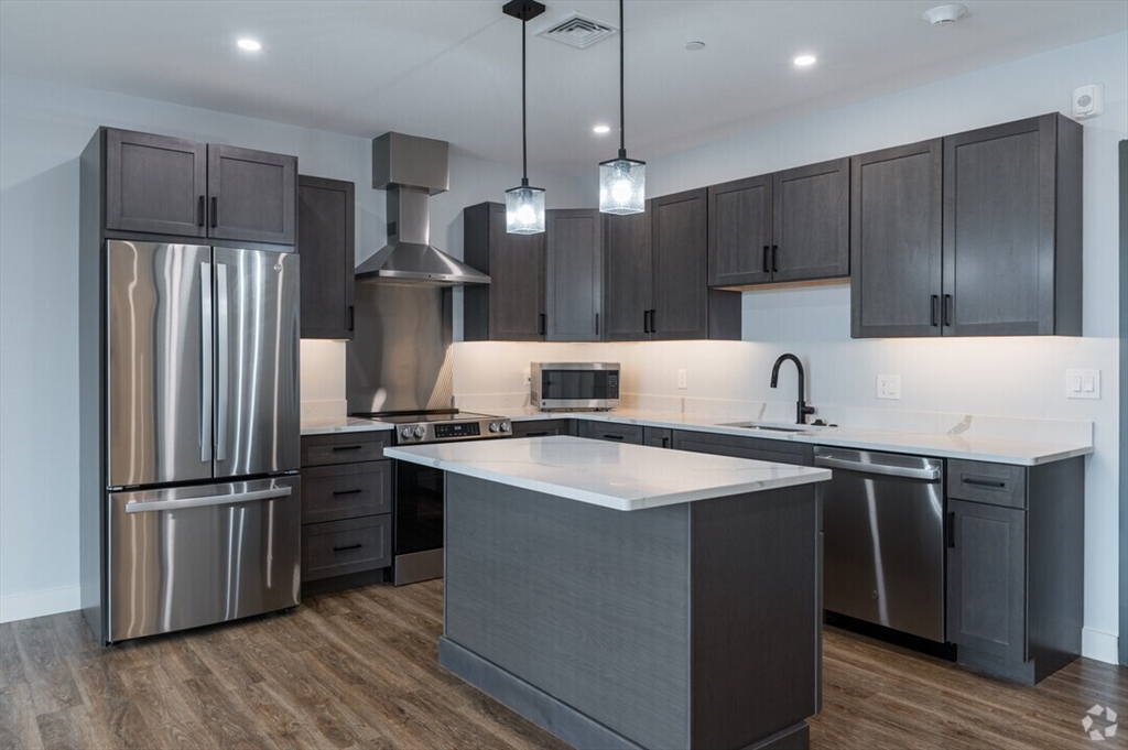 a kitchen with stainless steel appliances granite countertop a refrigerator a sink and a stove