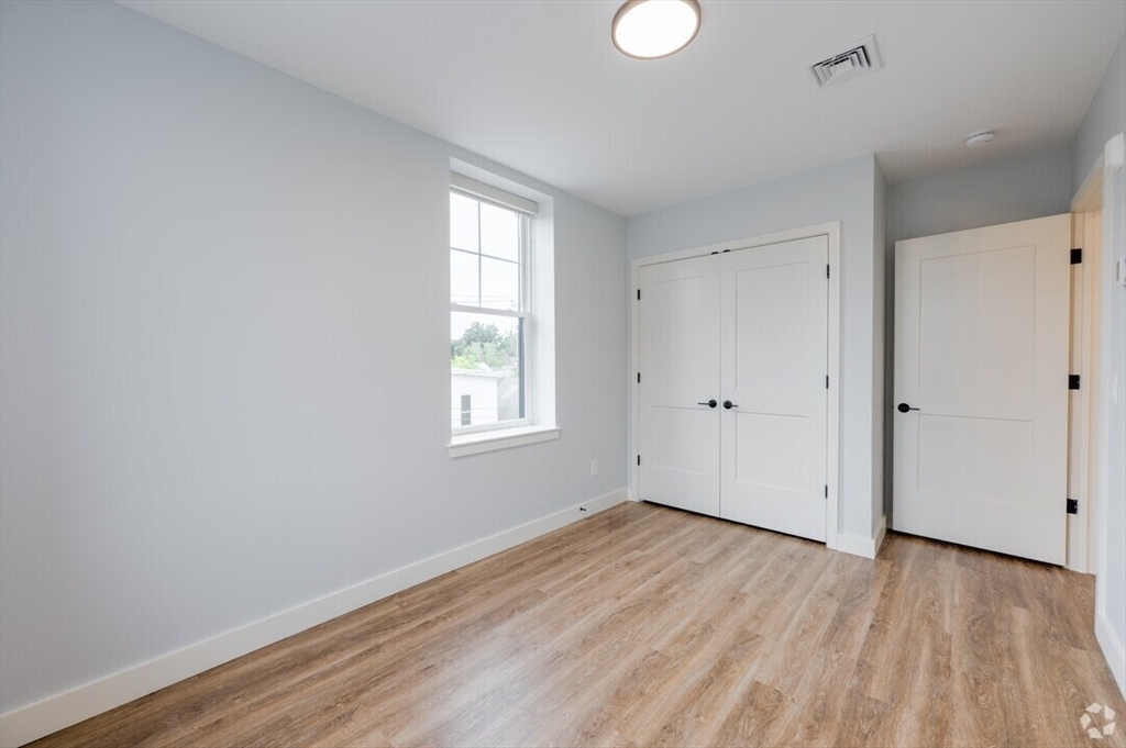 21 Summer Street, Unit 302 Natick, MA 01760 - Photo 3 of 9 wooden floor in an empty room with a window
