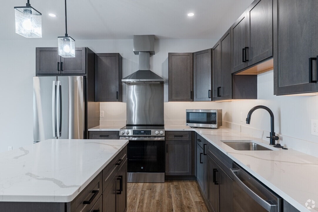 21 Summer Street, Unit 302 Natick, MA 01760 - Photo 4 of 9 a kitchen with stainless steel appliances a sink a stove a refrigerator and cabinets