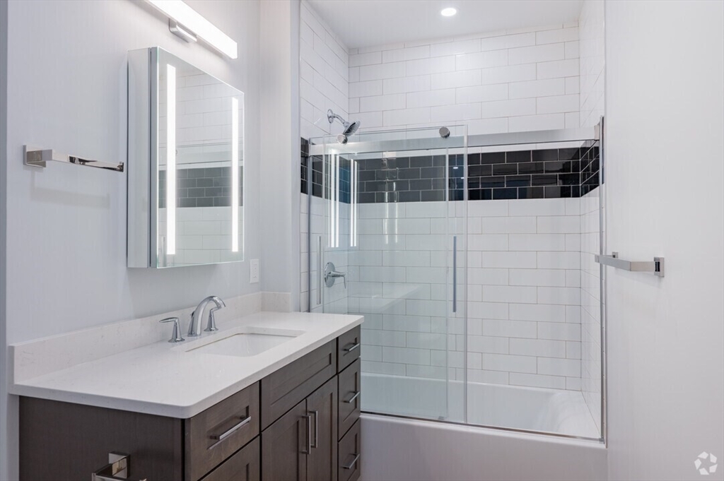 21 Summer Street, Unit 302 Natick, MA 01760 - Photo 5 of 9 a bathroom with a sink a mirror and shower