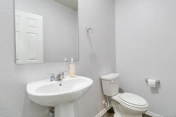a bathroom with a sink a toilet and mirror